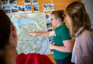 Een gids wijst een kaart aan bij Camping La Pinède - Excenevex in Auvergne-Rhône-Alpes, Frankrijk.