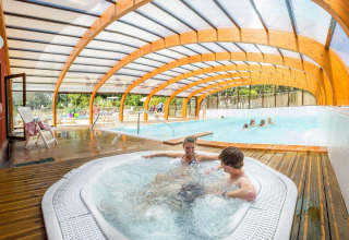 Überdachtes Schwimmbad mit Whirlpool und Gästen, Camping La Pinède - Excenevex, Auvergne-Rhône-Alpes, Frankreich.