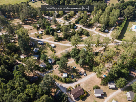 Vista aérea del parque vacacional Huttopia Les Châteaux en Centre-Val de Loire, Francia, rodeado de naturaleza.