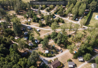 Luftfoto af ferieparken Huttopia Les Châteaux i Centre-Val de Loire, Frankrig, omgivet af træer og stier.