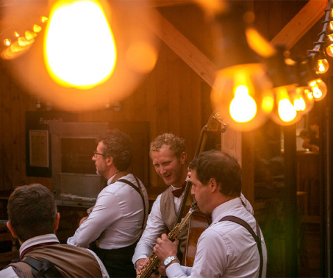 Muzikanten spelen onder warme sfeerverlichting bij Huttopia Les Châteaux, Centre-Val de Loire, Frankrijk.