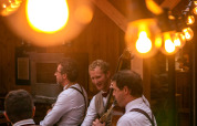 Musikere spiller under hyggelige lyskæder på en restaurant i Huttopia Les Châteaux, Centre-Val de Loire, Frankrig.
