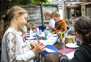 Children enjoy arts and crafts together outdoors at a holiday park in Centre-Val de Loire, France.