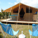 Safari Bungalow Classic-telt med træterrasse, blå havemøbler og afslappende stole i det fri.