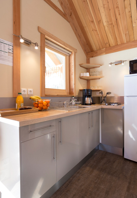 Moderne keuken in Chalet Montana Vista met houten plafond, daglicht, fruitmand en moderne apparatuur.