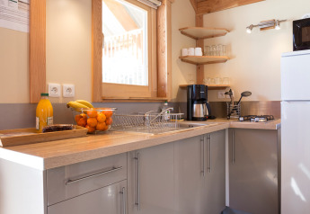 Cocina moderna en Chalet Montana Vista con techos de madera, mucha luz natural y frutero en la encimera.