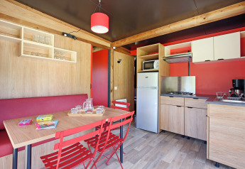 Moderne keuken en eetruimte in Chalet Evasion Bord de Rivière in Huttopia Les Châteaux, Frankrijk.