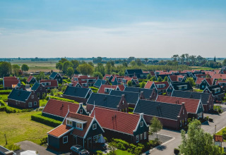 Luchtbeeld van Tiny House-lodge in De Rijp, Nederland, met pittoreske huisjes en weelderig groene omgeving.