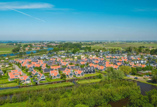 Vue aérienne de petites maisons aux toits rouges entourées de canaux à Tiny House de De Rijp, Pays-Bas.