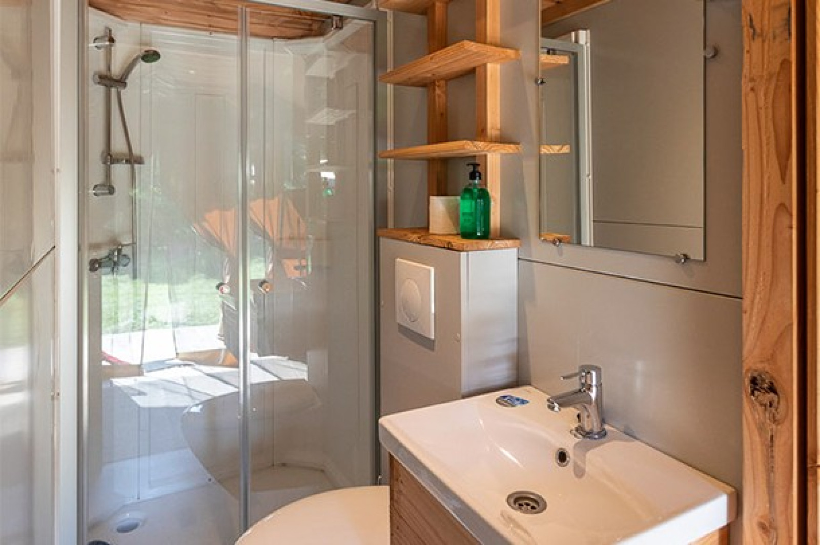 Modern badkamer met douchecabine, wastafel en spiegel in een safaritent bij Camping de Paris, Frankrijk.