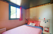 Dormitorio en una caravana gitana en Camping de Paris, Francia, con ropa de cama colorida y decoración acogedora.