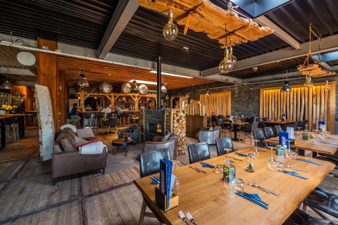 Interno del lodge L-Pavilion a Poort van Zeeland nei Paesi Bassi, arredato in legno e atmosfera accogliente.