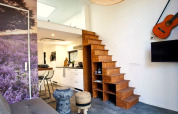 Modernes Interieur im Tiny House at De Zanding, Niederlande, mit Holztreppe, Küche und Gitarre.