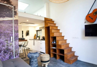 Intérieur moderne de tiny house à Tiny House at De Zanding, Pays-Bas, avec escalier en bois et cuisine.