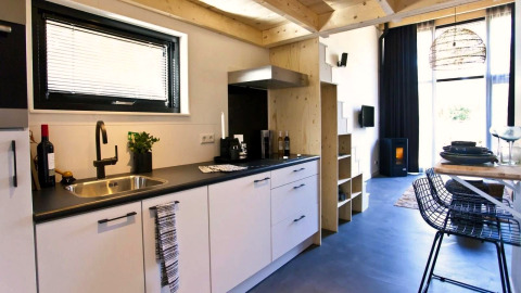 Moderne, compacte keuken met woonkamer in een Tiny House bij De Zanding, Nederland, stijlvol ingericht.