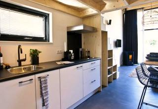 Moderne, compacte keuken met woonkamer in een Tiny House bij De Zanding, Nederland, stijlvol ingericht.