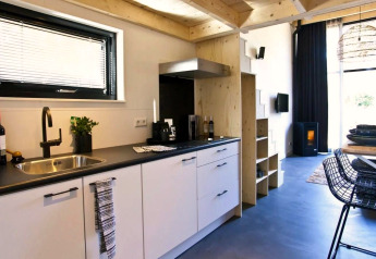 Modernes, kompaktes Küchen- und Wohnzimmer im Tiny House bei De Zanding, Niederlande, stilvoll eingerichtet.