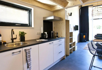 Moderne, compacte keuken met woonkamer in een Tiny House bij De Zanding, Nederland, stijlvol ingericht.