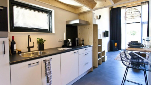 Moderne, compacte keuken en woonkamer in een Tiny House bij De Zanding, Nederland, stijlvol ingericht.