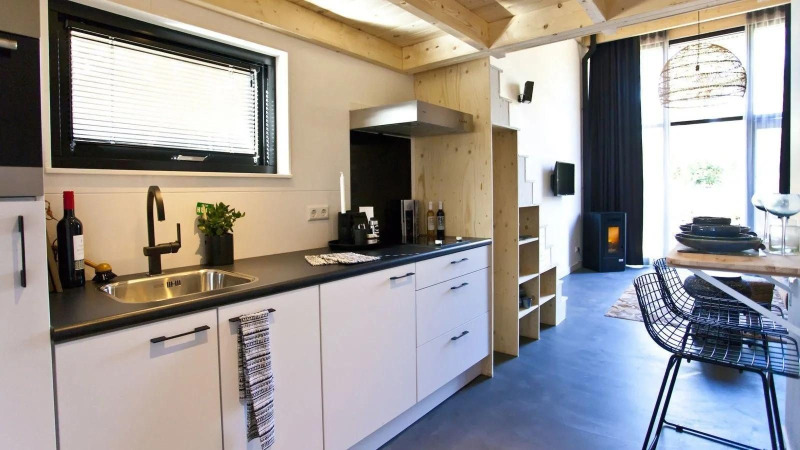 Modern, compact kitchen and living area in a Tiny House at De Zanding, Netherlands, with stylish decor.