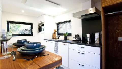 Cuisine moderne et bien équipée dans Tiny House à De Zanding, Pays-Bas, vue depuis le coin repas en bois.