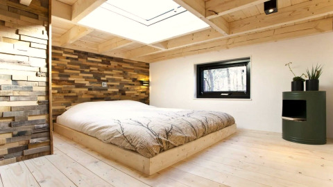Moderne slaapkamer in Tiny House bij De Zanding, Nederland, met houten decor en groot dakraam.