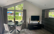 Moderne Berkel-Lodge bei De Zanding, Niederlande, Essbereich, Fernseher und stilvolles Interieur.