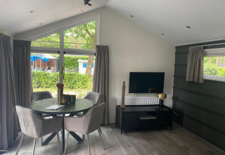 Moderne lodge Berkel bij De Zanding in Nederland met eethoek, tv, tafel en stijlvol interieur.