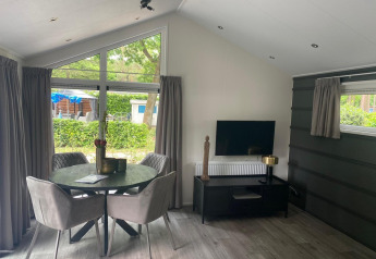 Moderna lodge Berkel a De Zanding nei Paesi Bassi, con zona pranzo, TV e arredamento elegante.