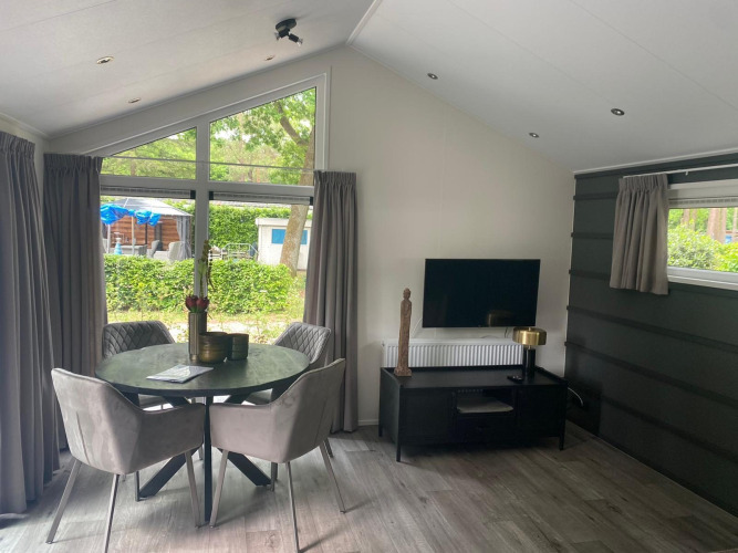Modern Berkel lodge at De Zanding, Netherlands, with dining area, TV, round table and elegant decor.