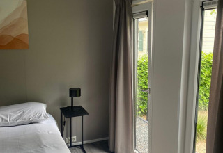 Modern ingerichte slaapkamer bij Berkel-lodge in De Zanding, Nederland, met grote ramen en rustig interieur.