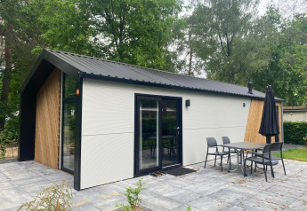 Lodge moderne Berkel à De Zanding aux Pays-Bas, terrasse extérieure, meubles de jardin et arbres.