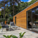 Moderne wellness lodge ved De Zanding i Nederlandene med træfacade, terrasse og havemøbler i det fri.