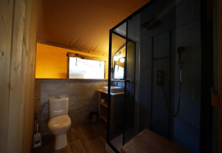 Safari-Zeltbadezimmer in der Lodgetent De Zanding, Niederlande, mit WC, Dusche und Waschbecken.