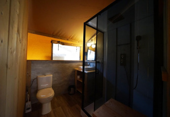 Safari-Zeltbadezimmer in der Lodgetent De Zanding, Niederlande, mit WC, Dusche und Waschbecken.