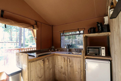 Vue intérieure d’une cuisine de tente safari au Lodgetent de De Zanding aux Pays-Bas, avec électroménagers.