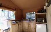 Vista interior de la cocina de una tienda safari en Lodgetent de De Zanding, Países Bajos, con electrodomésticos.