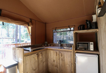 Vue intérieure d’une cuisine de tente safari au Lodgetent de De Zanding aux Pays-Bas, avec électroménagers.