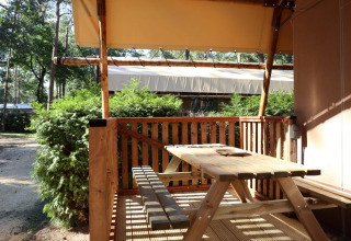 Udendørs terrasse med træbord og bænk ved Lodgetent safari telt på De Zanding campingplads i Holland.