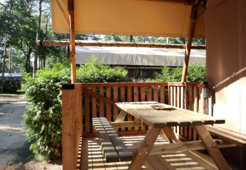 Udendørs terrasse med træbord og bænk ved Lodgetent safari telt på De Zanding campingplads i Holland.