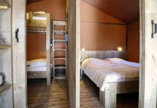 Intérieur d'une tente safari Lodgetent à De Zanding, Pays-Bas, avec lits superposés et lit double.