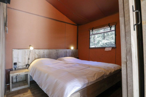 Schlafzimmer mit Doppelbett aus Holz im Safarizelt Lodgetent auf De Zanding in den Niederlanden.