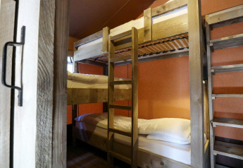 Vue intérieure de lits superposés dans une tente safari Lodgetent à De Zanding, Pays-Bas, avec meubles en bois.