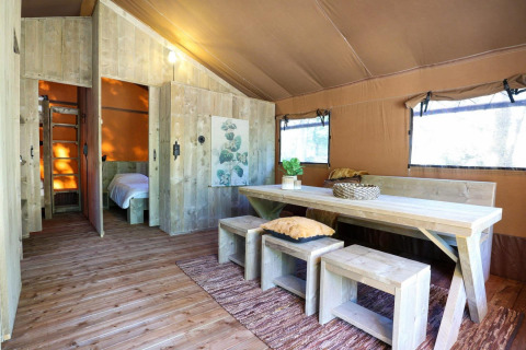 Intérieur de tente safari Lodgetent à De Zanding aux Pays-Bas, avec mobilier et décoration en bois.