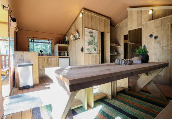 Interior of a safari tent Lodgetent at De Zanding in the Netherlands, featuring rustic wooden furniture.