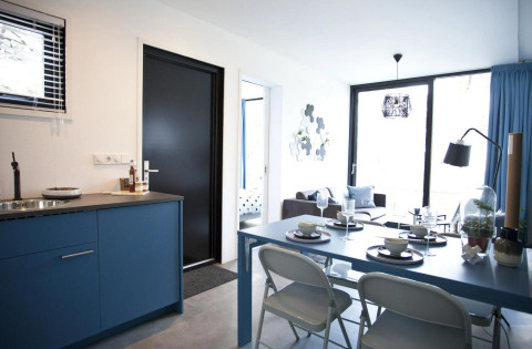 Modern Modus L lodge at De Zanding, Netherlands, featuring blue kitchen, dining area, and bright living room.