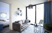 Modernes Wohnzimmer in der Modus L Lodge bei De Zanding, Niederlande, mit Sofa, Fenster und Schlafzimmer.