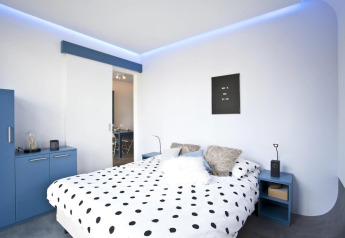 Camera moderna al Modus L di De Zanding nei Paesi Bassi, con mobili blu e illuminazione soffusa.