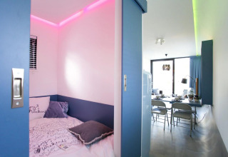 Habitación moderna en la lodge Modus L en De Zanding, Países Bajos, con luces LED y diseño funcional.