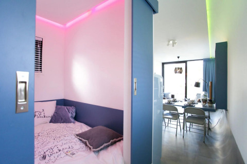 Chambre moderne à la lodge Modus L à De Zanding, Pays-Bas, avec éclairage LED coloré et décoration élégante.